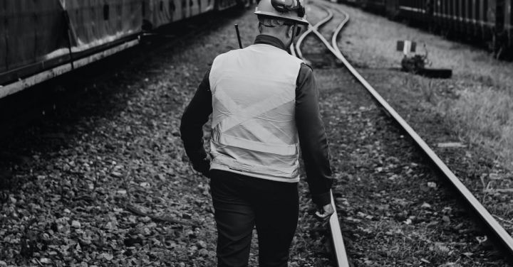 Railroad Worker - Back View of a Railroad Worker Walking on the Train Tracks