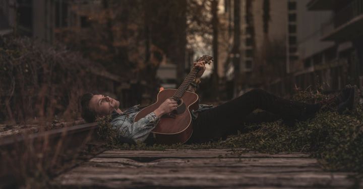 Train Music - Man Lying Down on Ground While Playing Guitar