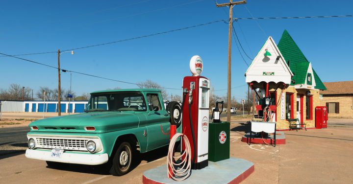 Diesel Locomotives - Green Single-cab Pickup Truck Beside a Gas Pump Station