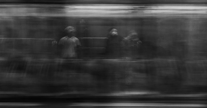 High-speed Rail - Black and white shot of unrecognizable person standing near window in subway car while riding