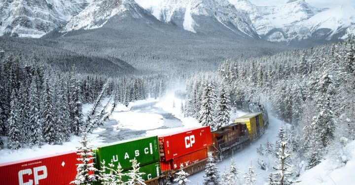 Trains In Movies - A Moving Train on a Snow Covered Ground Near the Snow Covered Trees and Mountains