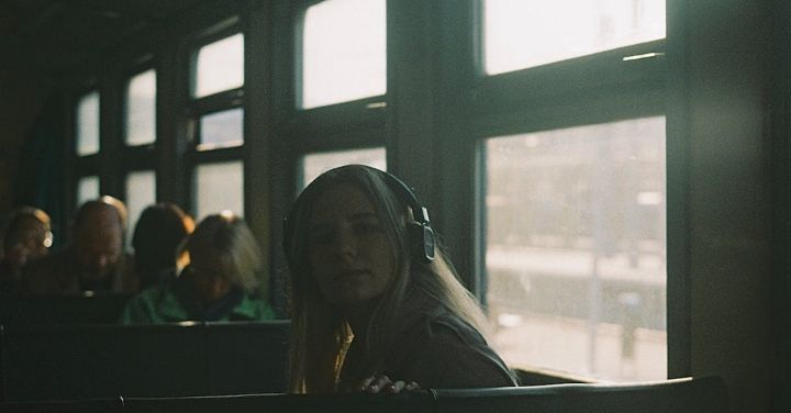 Train Music - Young female with headphones sitting on passenger seat in crowded train car near window while listening to music during trip in daytime